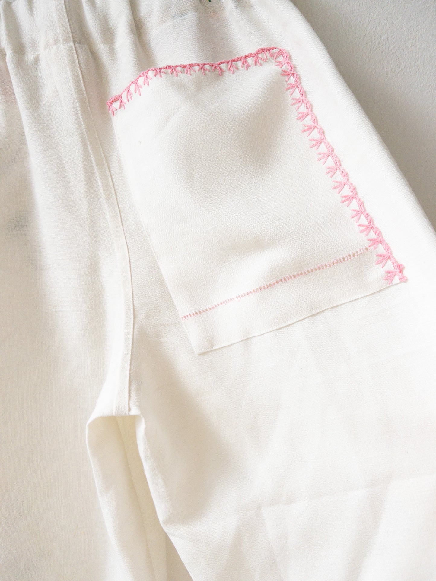 White pants with pink embroidery